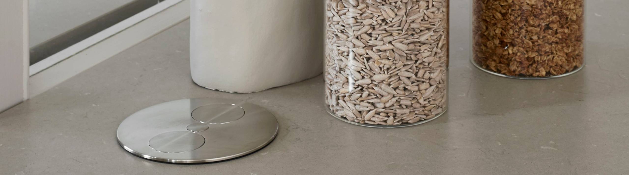 Nærbillede af lukket Powerport i beige køkkenø Athena Sand fra INVITA