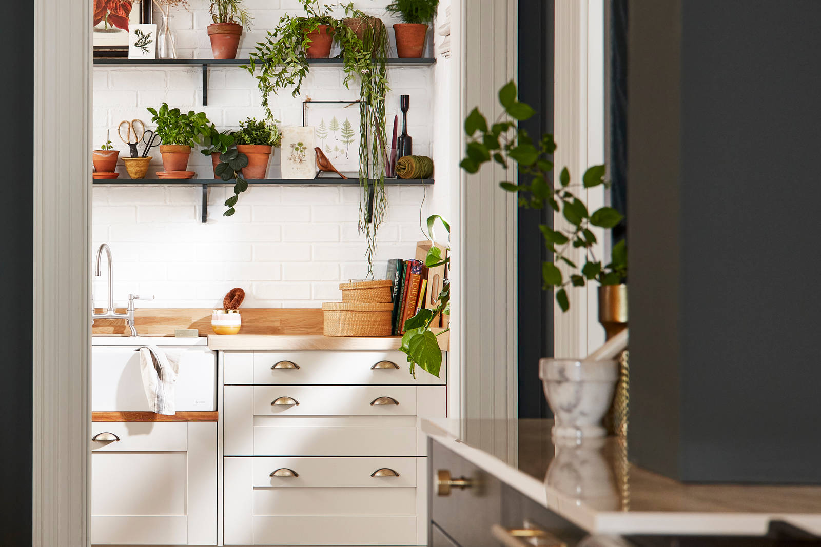 Ludlow, a traditional Shaker-style kitchen range in the shade Arboretum Green combined with a white utility room next door.