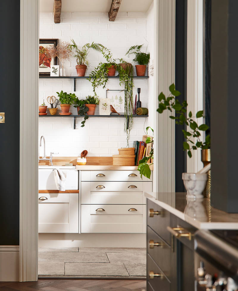 Ludlow, a traditional Shaker-style kitchen range in the shade Arboretum Green combined with a white utility room next door.