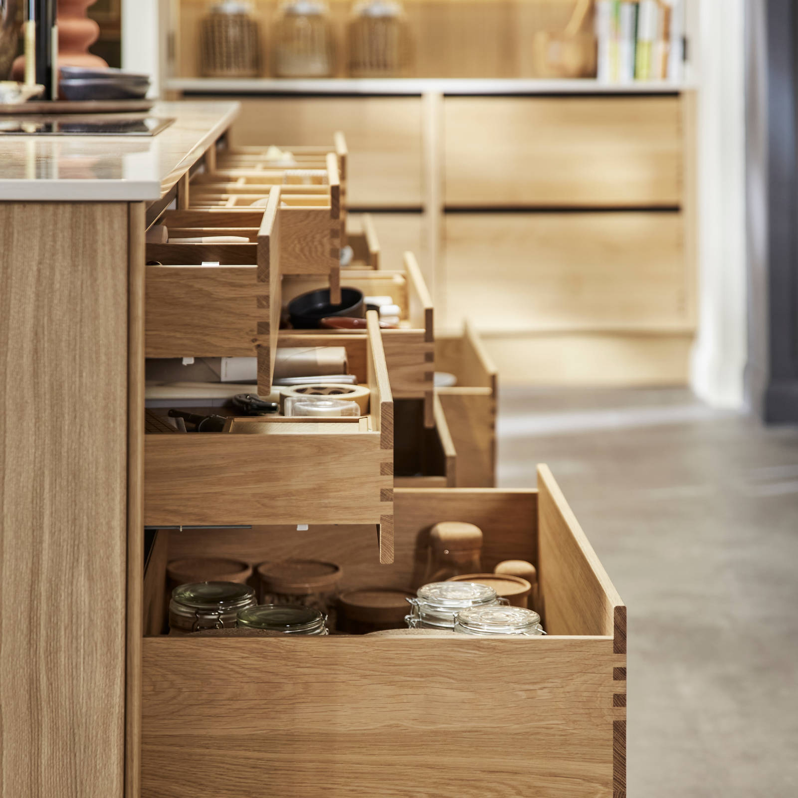 Side view of opened oak drawers in Nordic Craft kitchen island, drawers containing beautiful cookery ware.