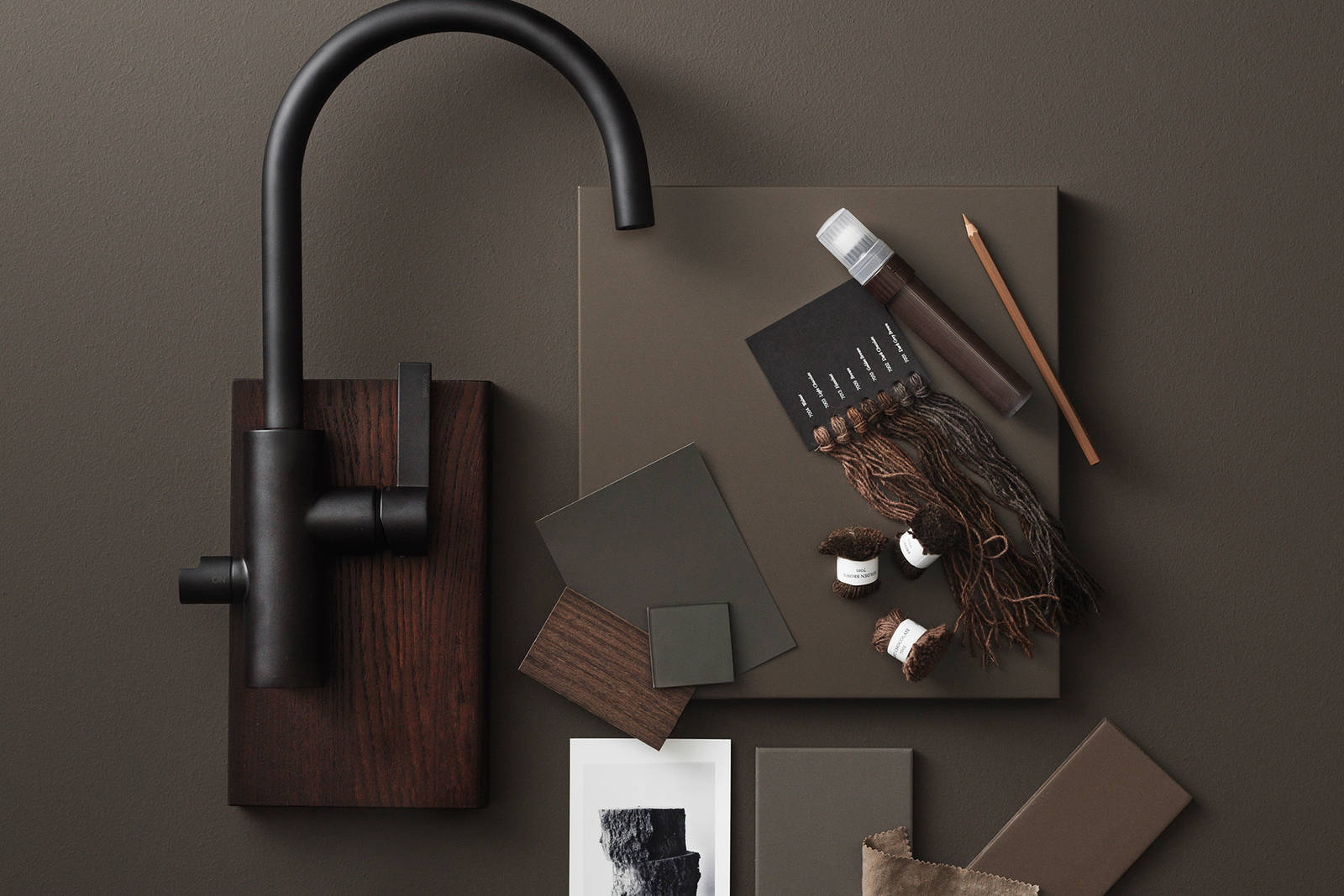 Slät brun kökslucka, slät kökslucka i brunbetsad ek, svart rundad blandare från tapwell, färgprover i naturmaterial