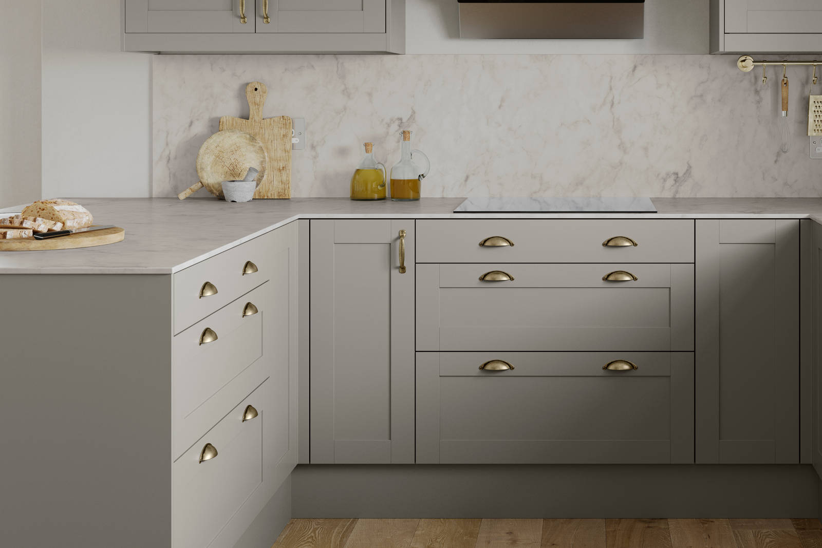 U-shape Tatton kitchen from Magnet in the shade Pebble, brass handles and accessories and a light marbled worktop with matching splashback.
