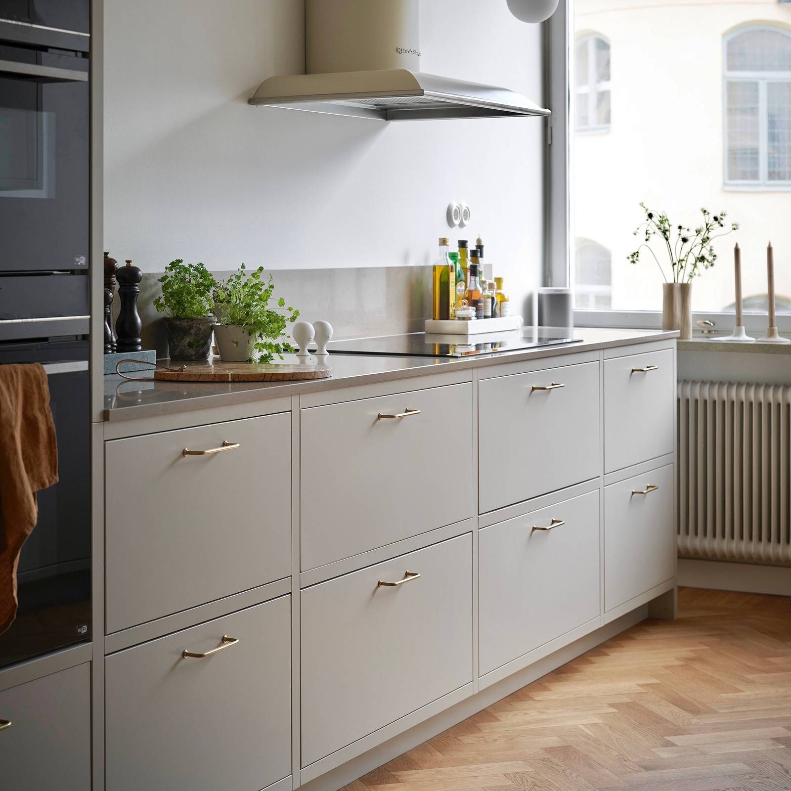 Forrammekøkken Athena Fusion i lys grå farve Sky fra INVITA med grå stein bordplade, rustfrit stål håndtag