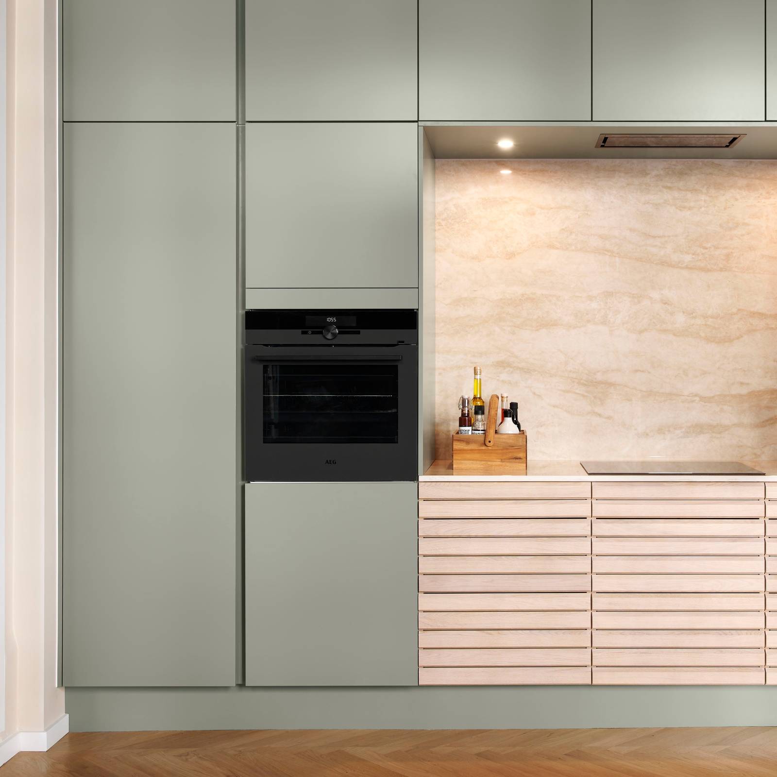 grebsfrie grønne køkkenet Highline Salvie med indfræsede greb i lågerne fra INVITA kombineret med med af egetræskøkken Ikon med håndsorterede lameller i massiv eg.