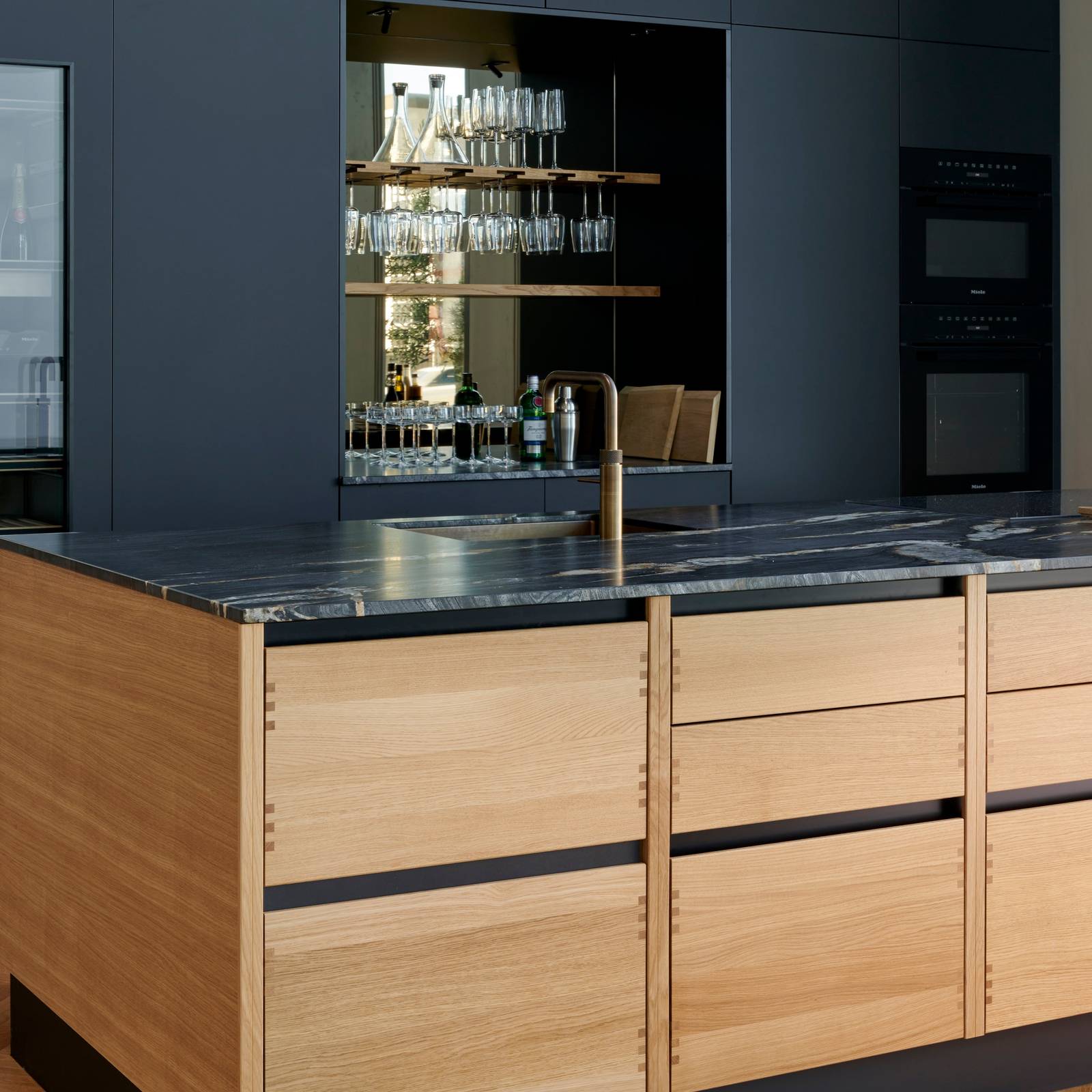 Køkkenøya Glød fra INVITA , skuffer i massivt egetræ med fingertappede samlinger og sort granit bordplade