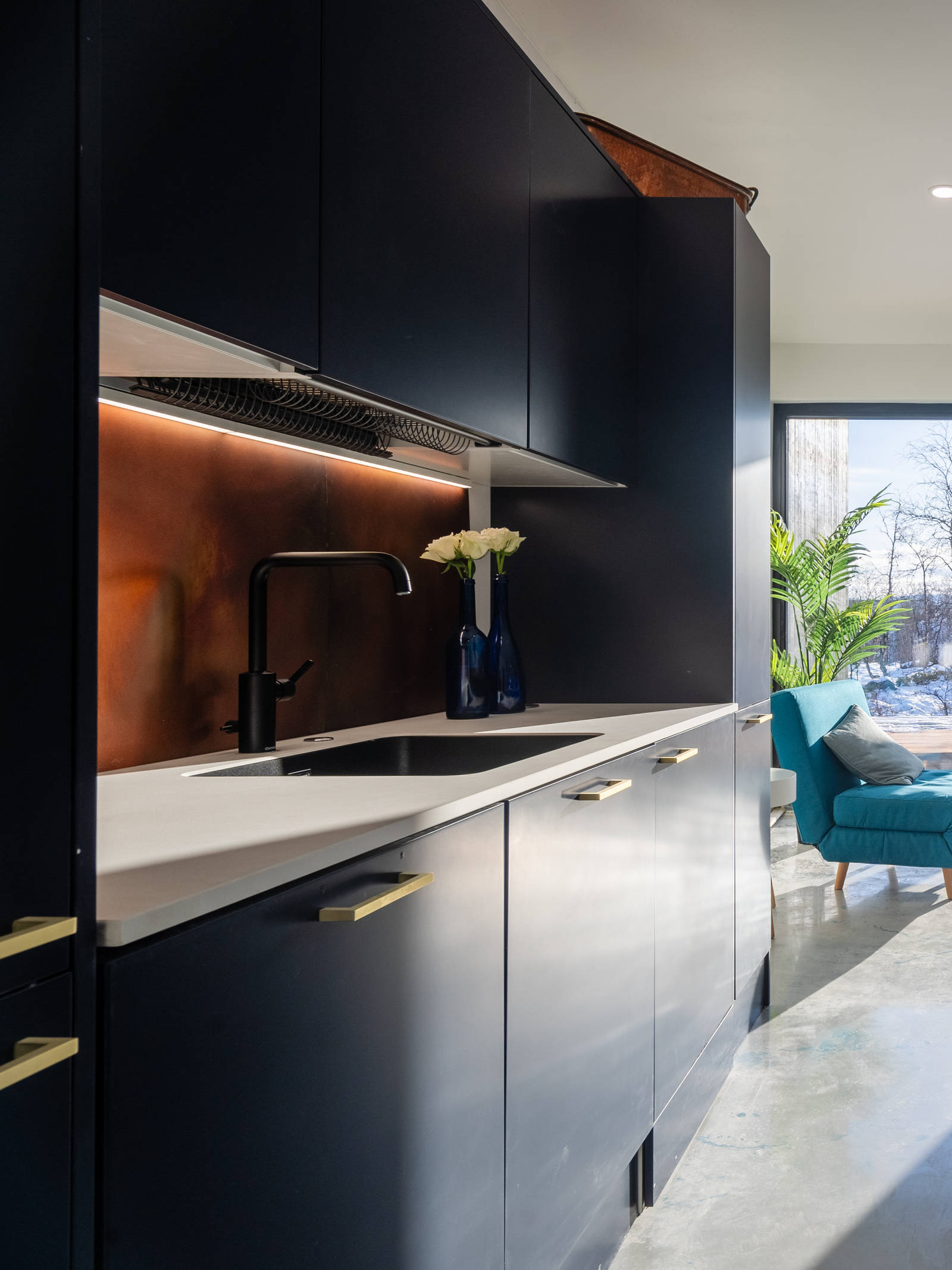 Novartin superlaminaattikeittiö rauhoittavassa luonnonvärisessä Meri-sävyssä, messinkivetimillä ja baarituoleilla varustetulla saarekkeella.