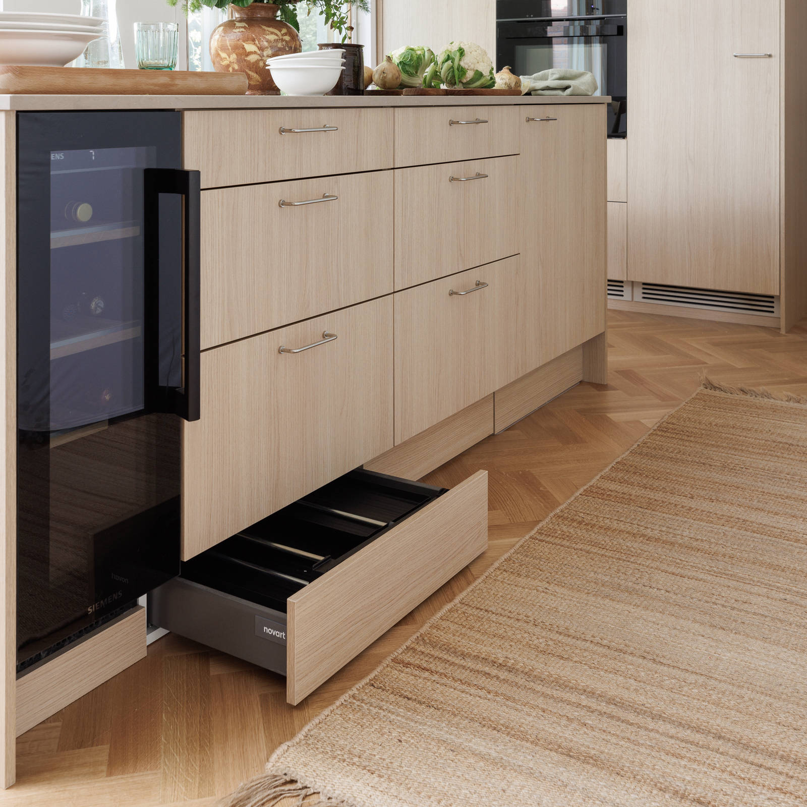 Aitoa luonnontammea Novartilta, yhdistelmä yhteensopivia puisia ja painonappikahvoja, keittiösaareke hanalla, tiskiallas ja ruostumattomasta teräksestä valmistettu työtaso.