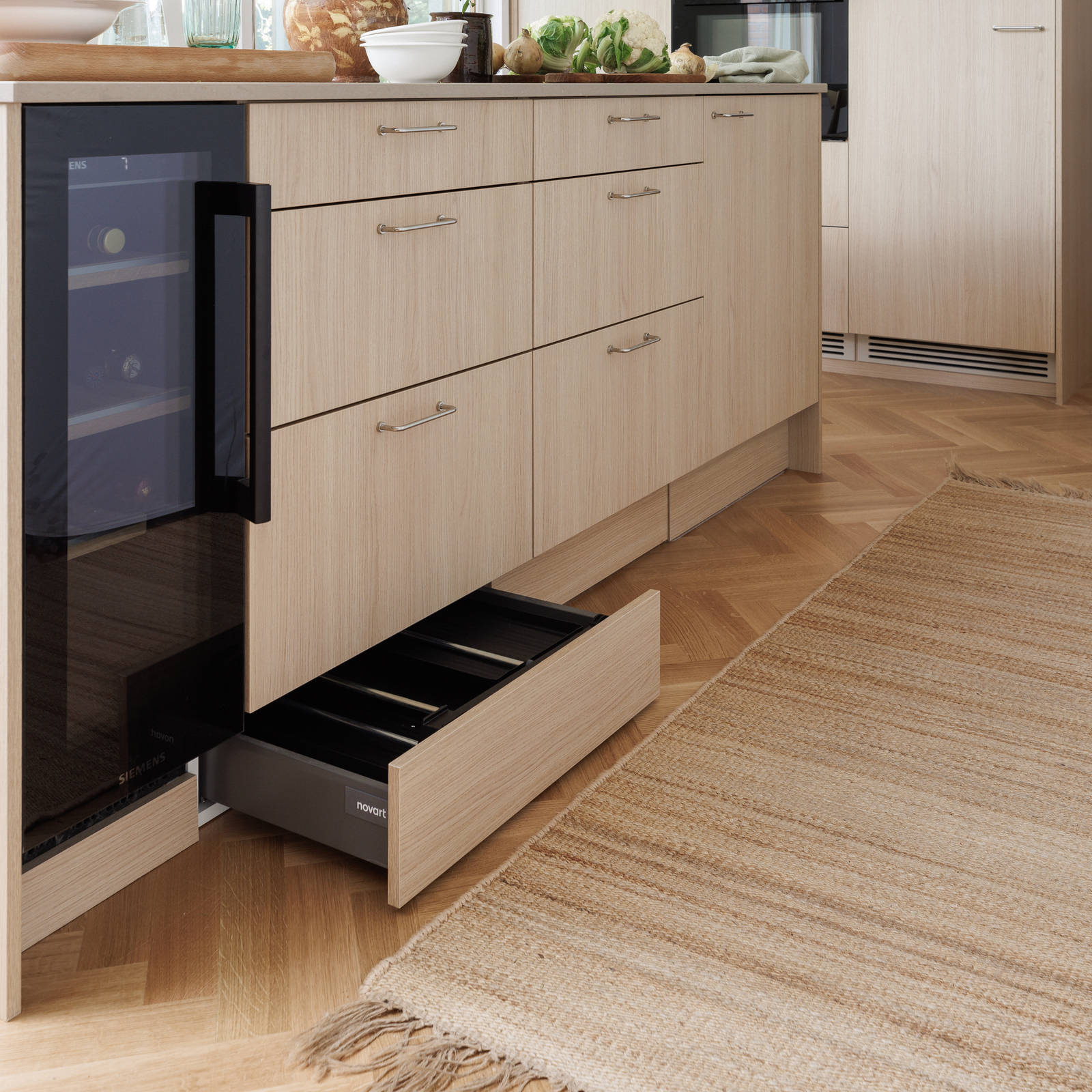 Aitoa luonnontammea Novartilta, yhdistelmä yhteensopivia puisia ja painonappikahvoja, keittiösaareke hanalla, tiskiallas ja ruostumattomasta teräksestä valmistettu työtaso.