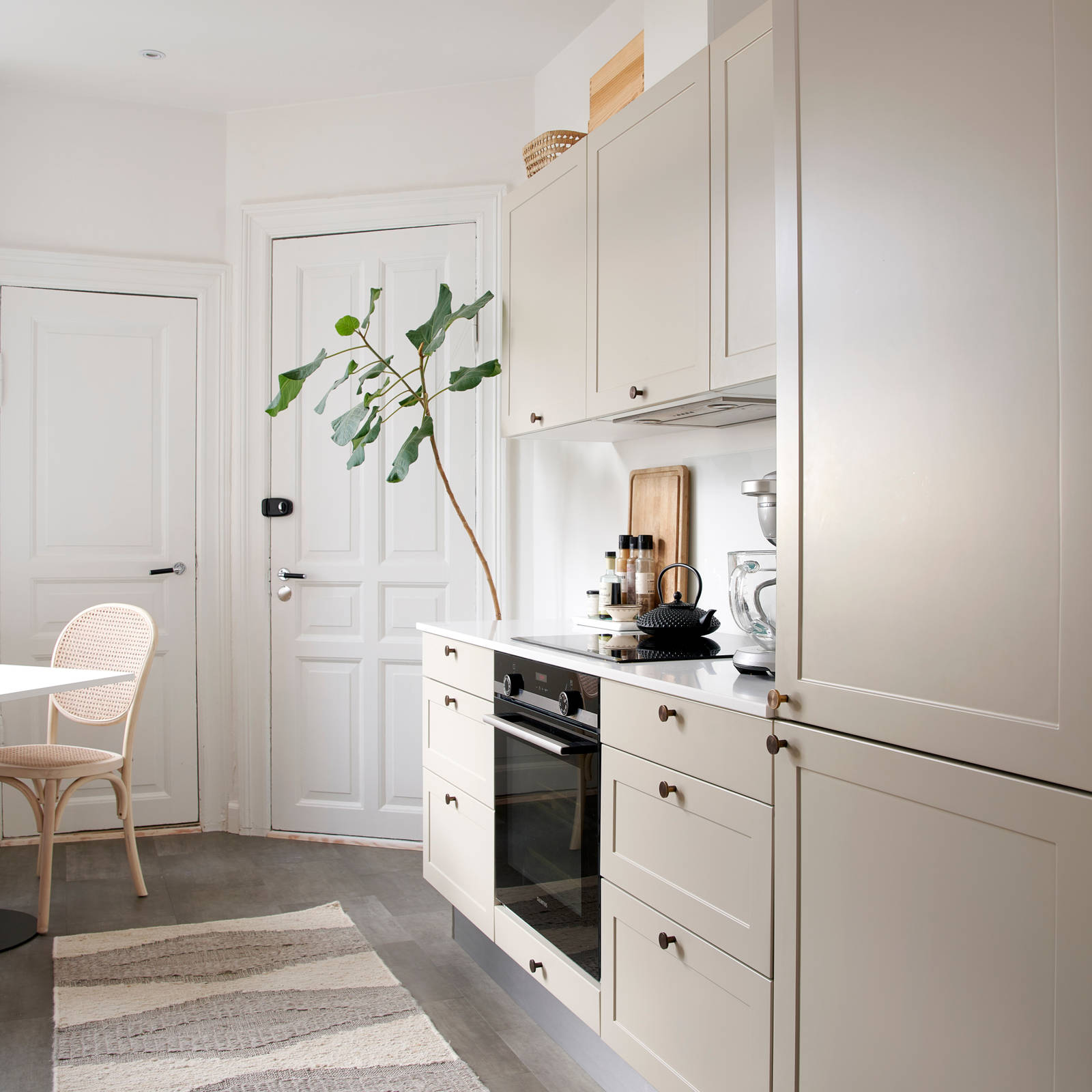 Beige retrokøkken Square Sand køkken fra INVITA med messing håndtag, hvid bordplade