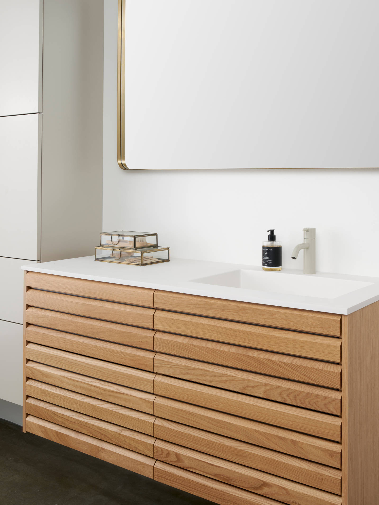Snedkerbadeværelse Ikon Finér eg natur fra INVITA med håndplukkede, massive egetræslameller med hvid vask og lys grå armatur