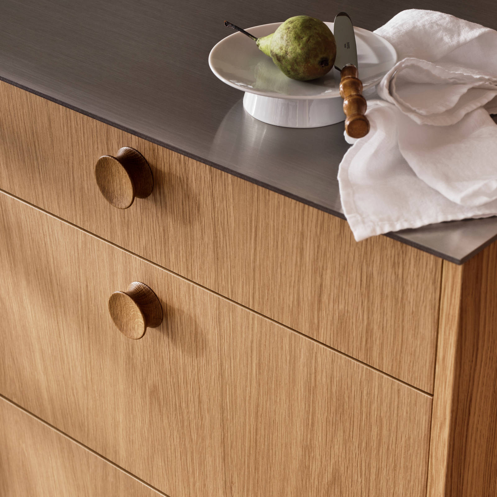 Nærbillede af køkkenlåger eg med eg greb på Jubilæumskøkken fra INVITA med elegant træfinér eg