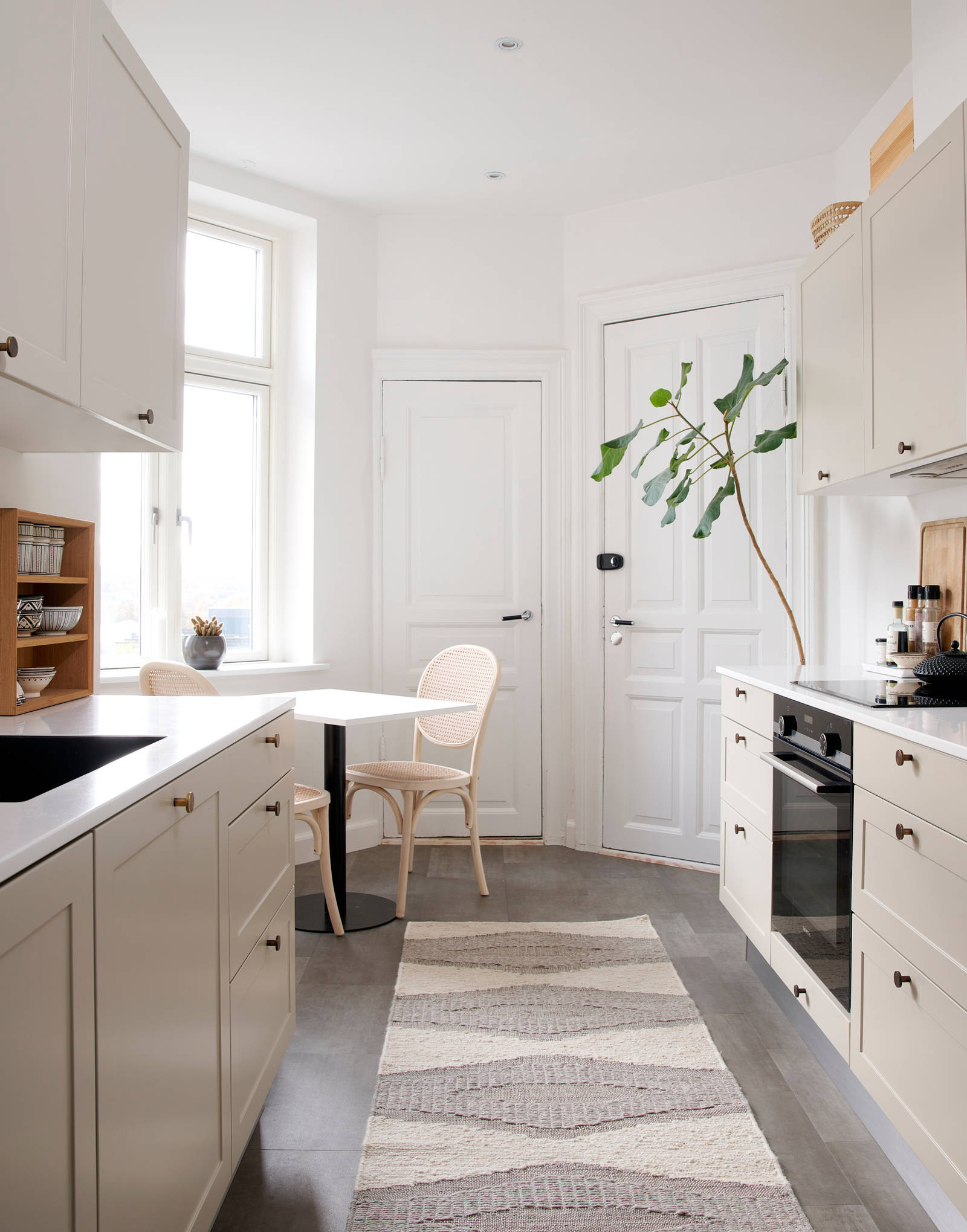 Beige retrokøkken Square Sand køkken fra INVITA med messing håndtag, hvid bordplade