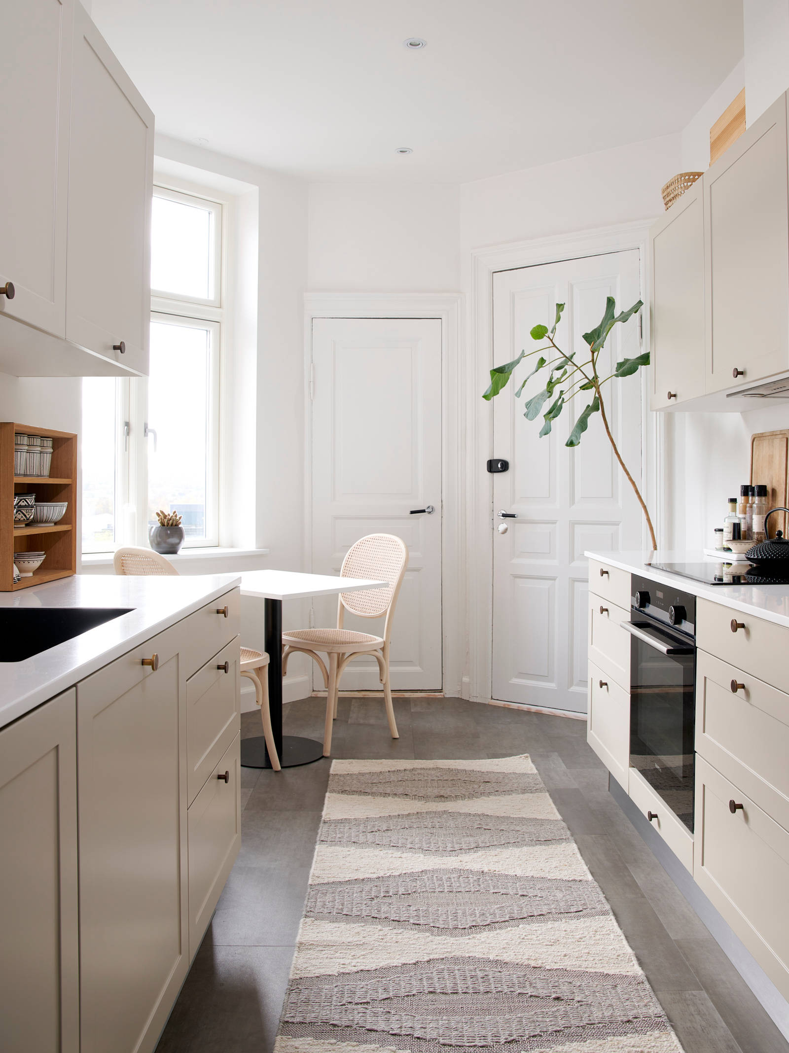 Beige retrokøkken Square Sand køkken fra INVITA med messing håndtag, hvid bordplade