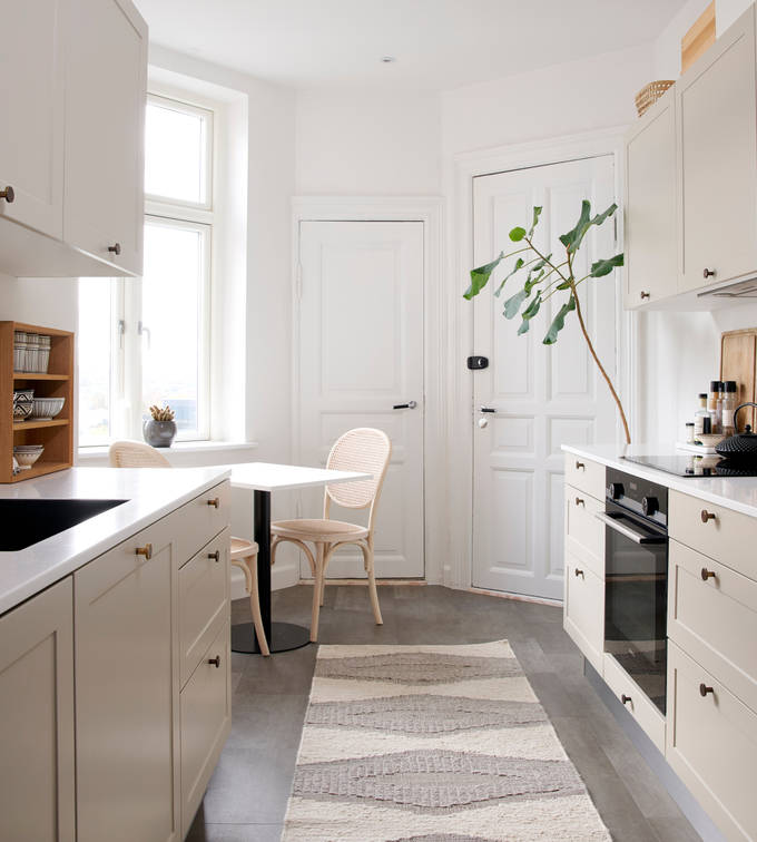 Beige retrokøkken Square Sand køkken fra INVITA med messing håndtag, hvid bordplade