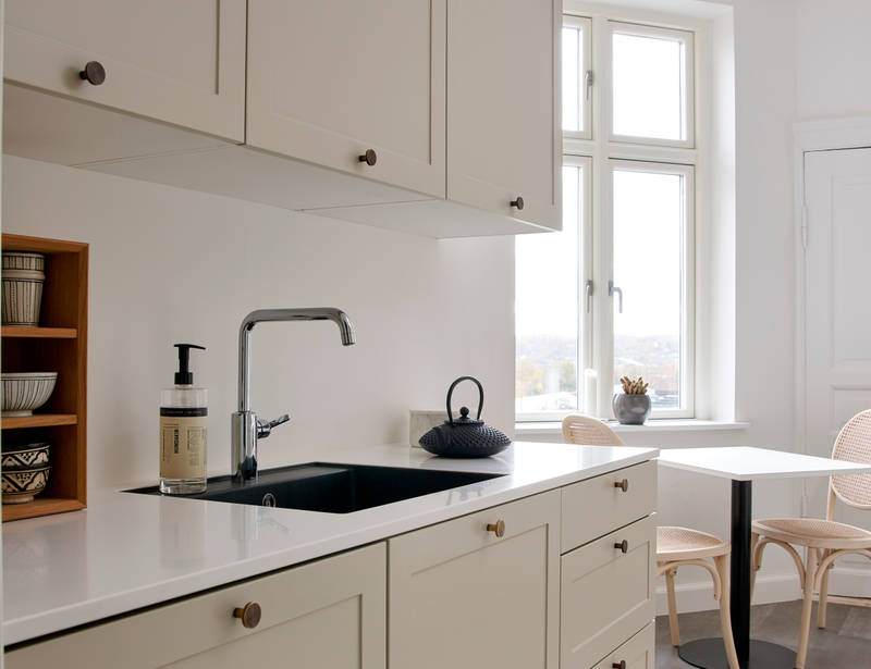 Beige retrokøkken Square Sand køkken fra INVITA med messing håndtag, hvid bordplade