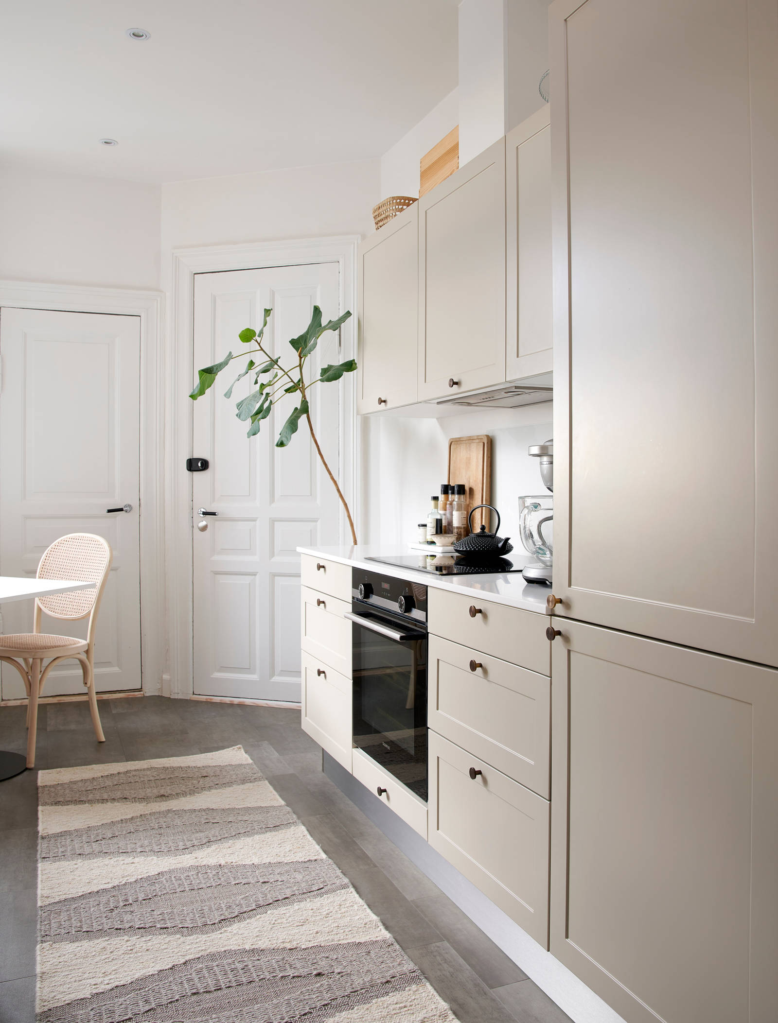 Beige retrokøkken Square Sand køkken fra INVITA med messing håndtag, hvid bordplade