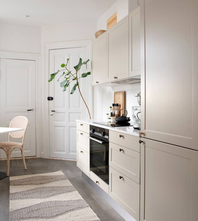 Beige retrokøkken Square Sand køkken fra INVITA med messing håndtag, hvid bordplade