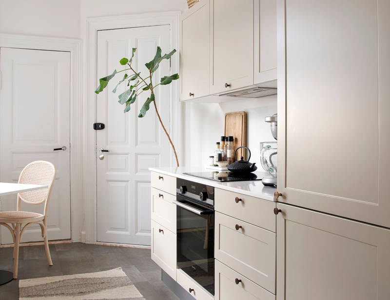 Beige retrokøkken Square Sand køkken fra INVITA med messing håndtag, hvid bordplade