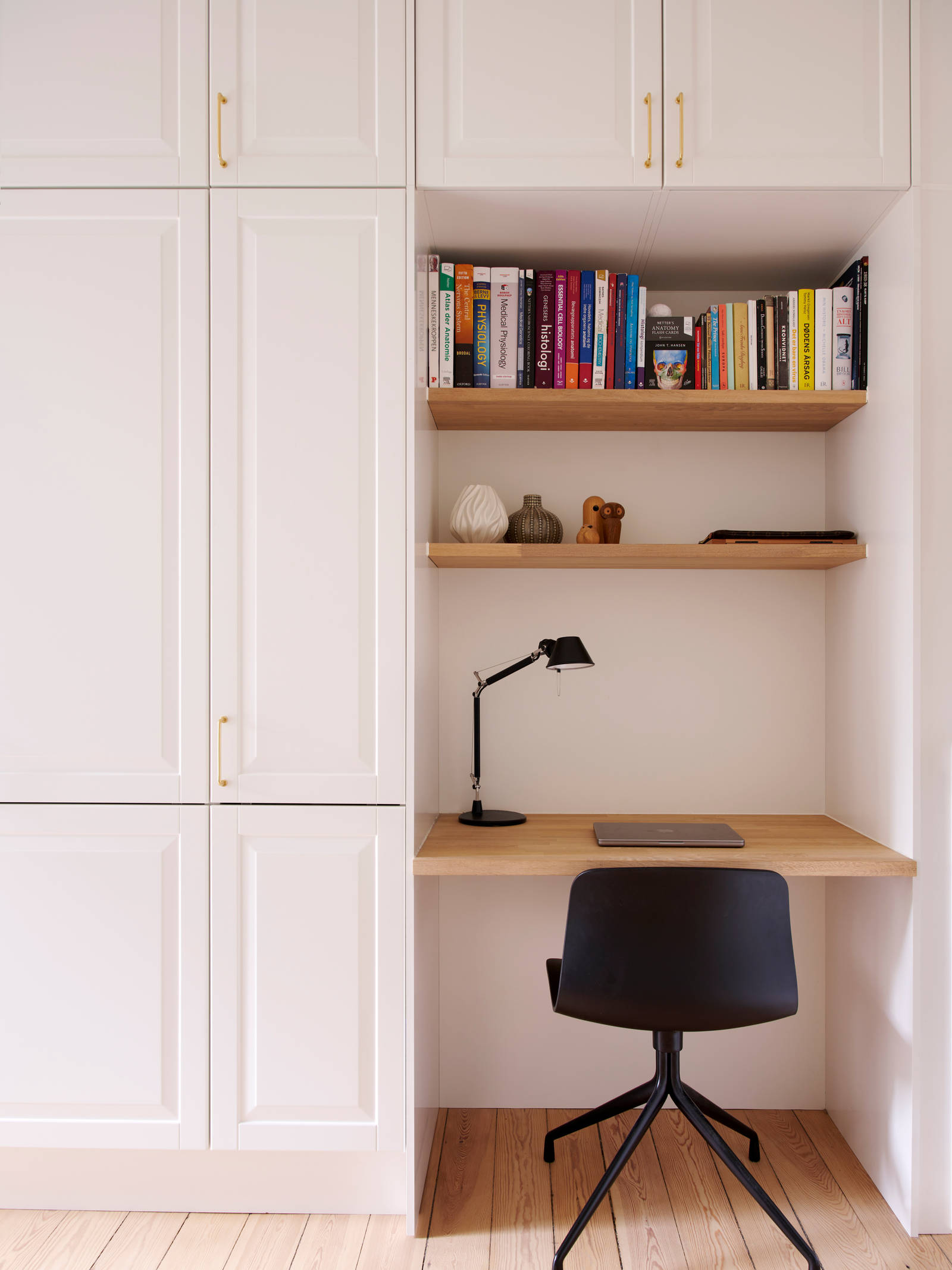 Hvid garderobe Nordic Frost fra INVITA med fyldningslåger og messinggreb, med indbygget bordplade med stol og væghylder til hjemmekontoret