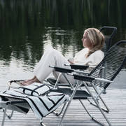 Lotta Agaton i en stol på bryggan vid Piteälven intill landstället