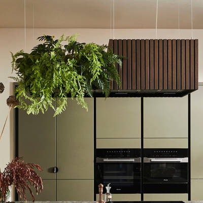 View through opened dark wood doors of the biophilic Dramatic neutral Balmoral Soho and Nordic Nature kitchen from Magnet and matching dark chairs by the bar area of the kitchen island.