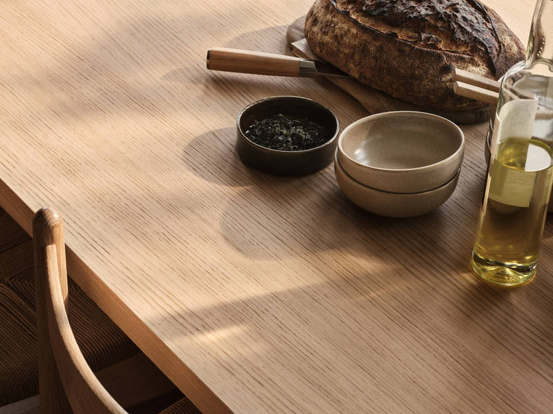 Bord och stol i trä med keramik och en flaska olivolja