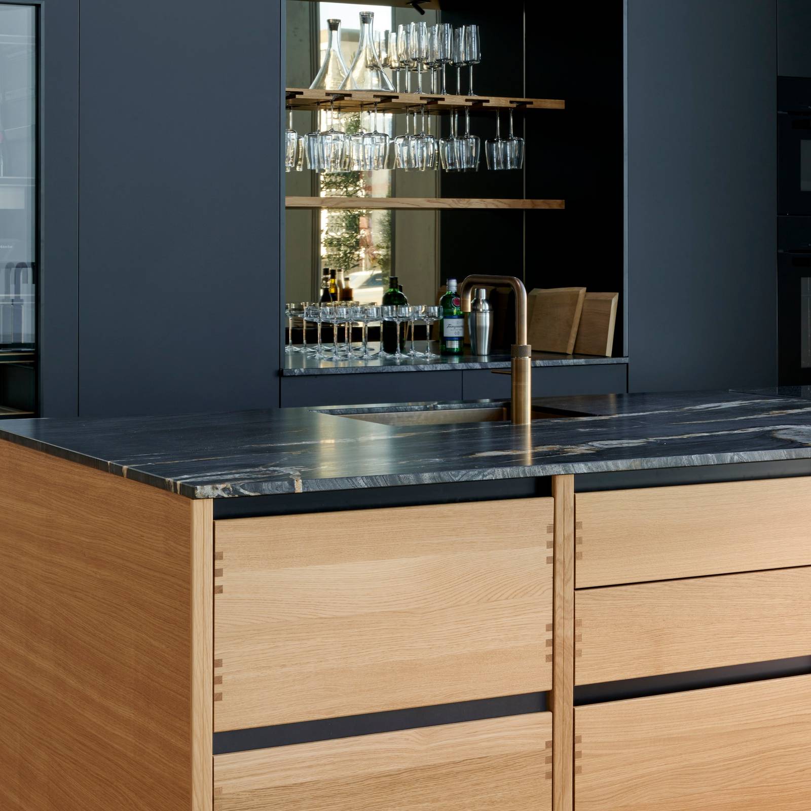 Køkkenøya Glød fra INVITA , skuffer i massivt egetræ med fingertappede samlinger og sort granit bordplade