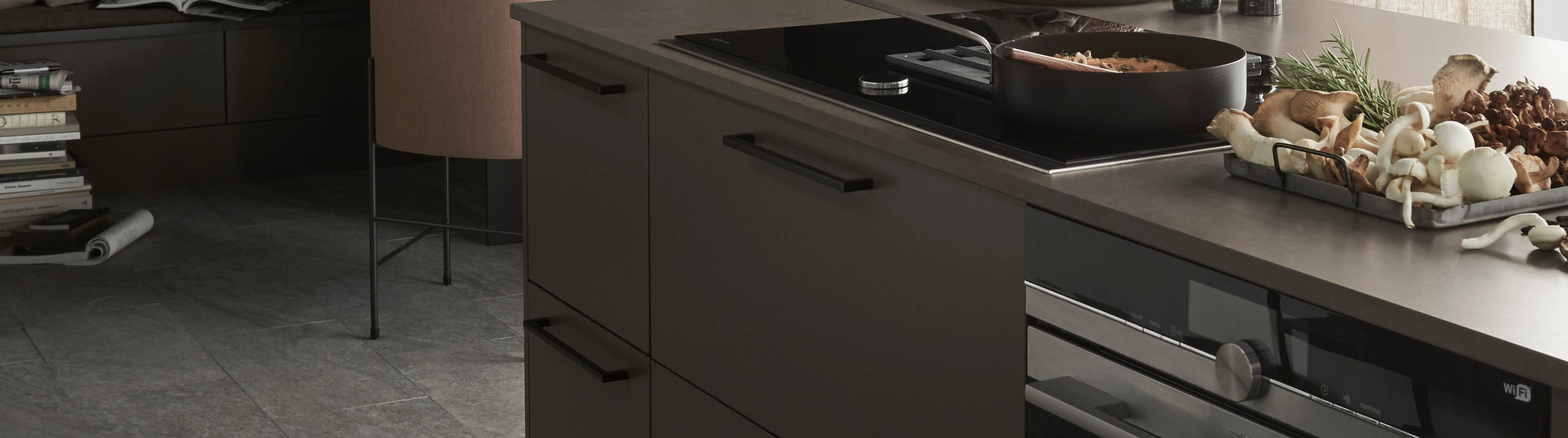 Lucka Arkitekt plus Bark målad i brun kulör. Köksö med bänkskiva Iron Bark i kvartskomposit. Matsalshörnet av väggskåp och sittbänk skapad av bänkskåp skapar inbjudande plats i köket.