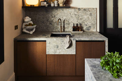 Sink area with Dekton in Ceppo backsplash and worktop, Nordic Nature cabinetry and a brass Quooker tap.