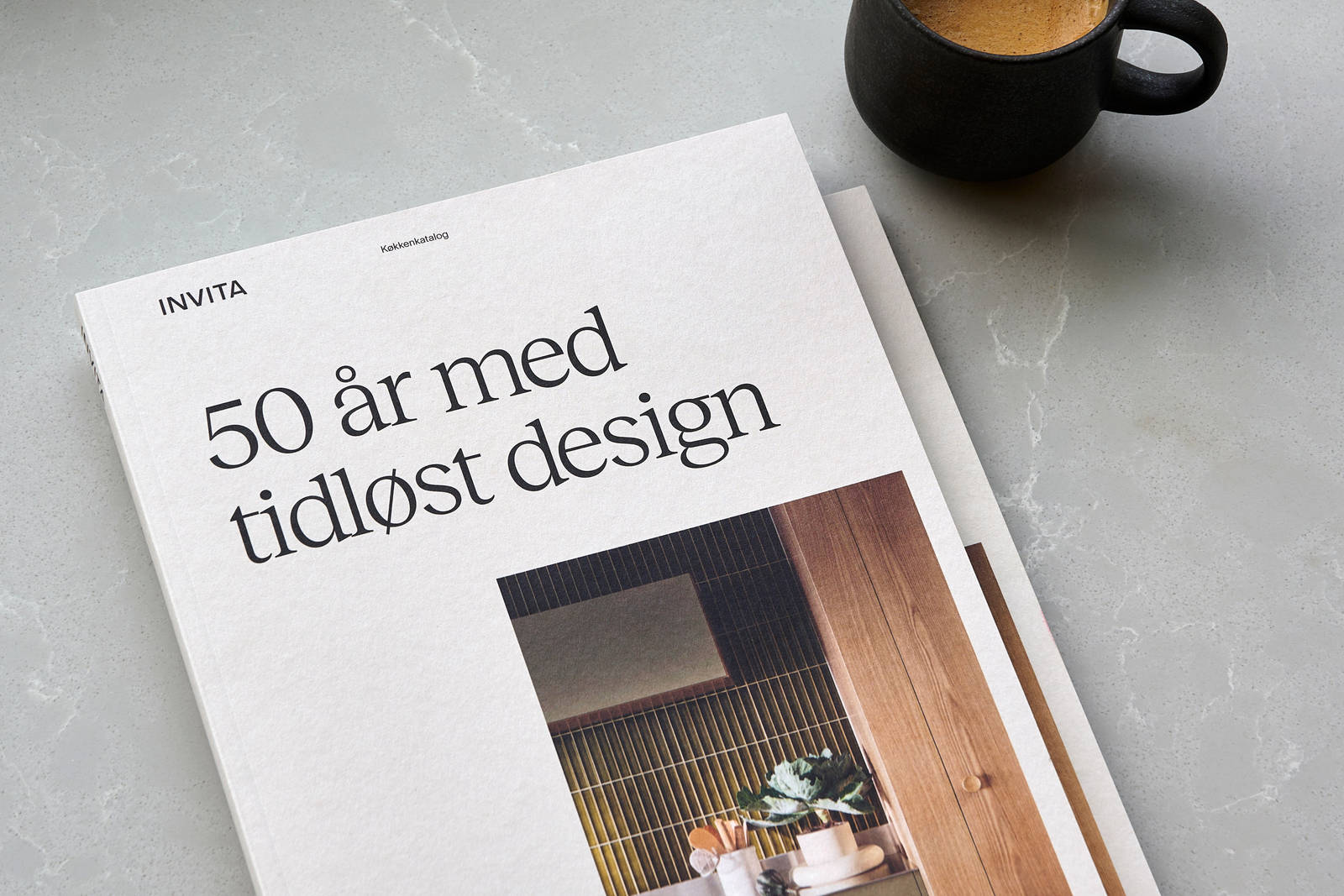 Katalog fra INVITA og kaffekop på bordet