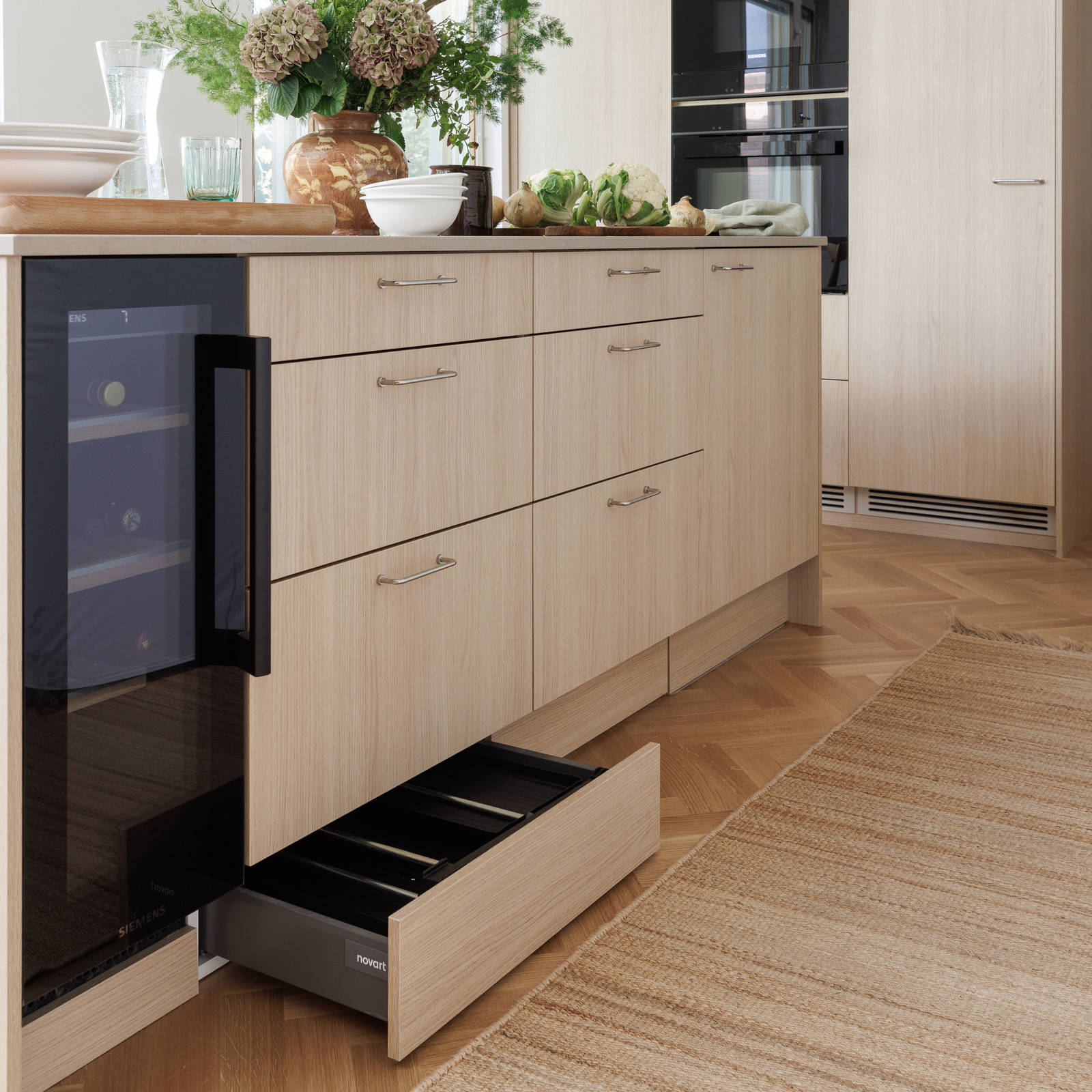 Aitoa luonnontammea Novartilta, yhdistelmä yhteensopivia puisia ja painonappikahvoja, keittiösaareke hanalla, tiskiallas ja ruostumattomasta teräksestä valmistettu työtaso.