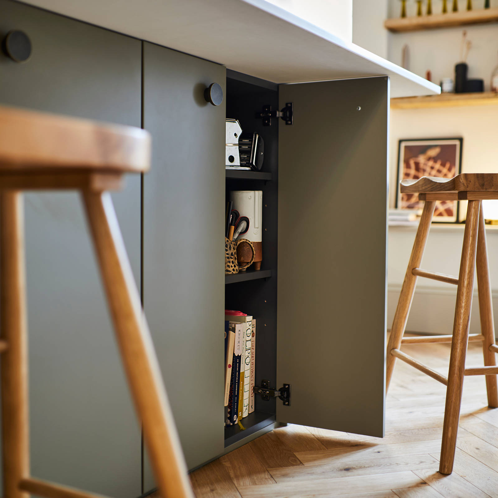 Close-up of opened cabinet in Soho Balmoral kitchen island, with light wood barstools