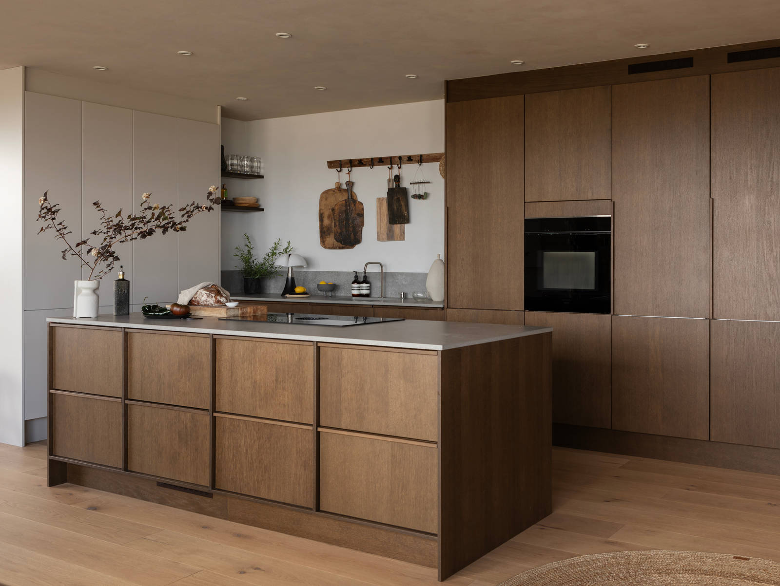 Køkkenø i brun egetræsfiner køkkenet Forever oak med matchende tre håndtag fra INVITA og beige højskabe Athena Sand