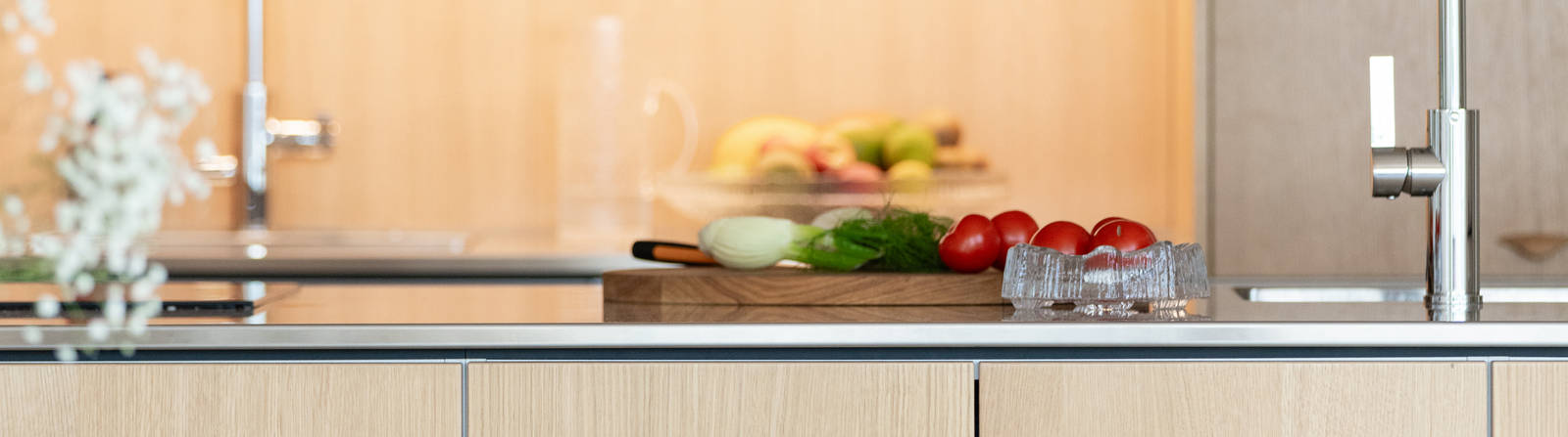 Aitoa luonnontammea Novartilta, yhdistelmä yhteensopivia puisia ja painonappikahvoja, keittiösaareke hanalla, tiskiallas ja ruostumattomasta teräksestä valmistettu työtaso.