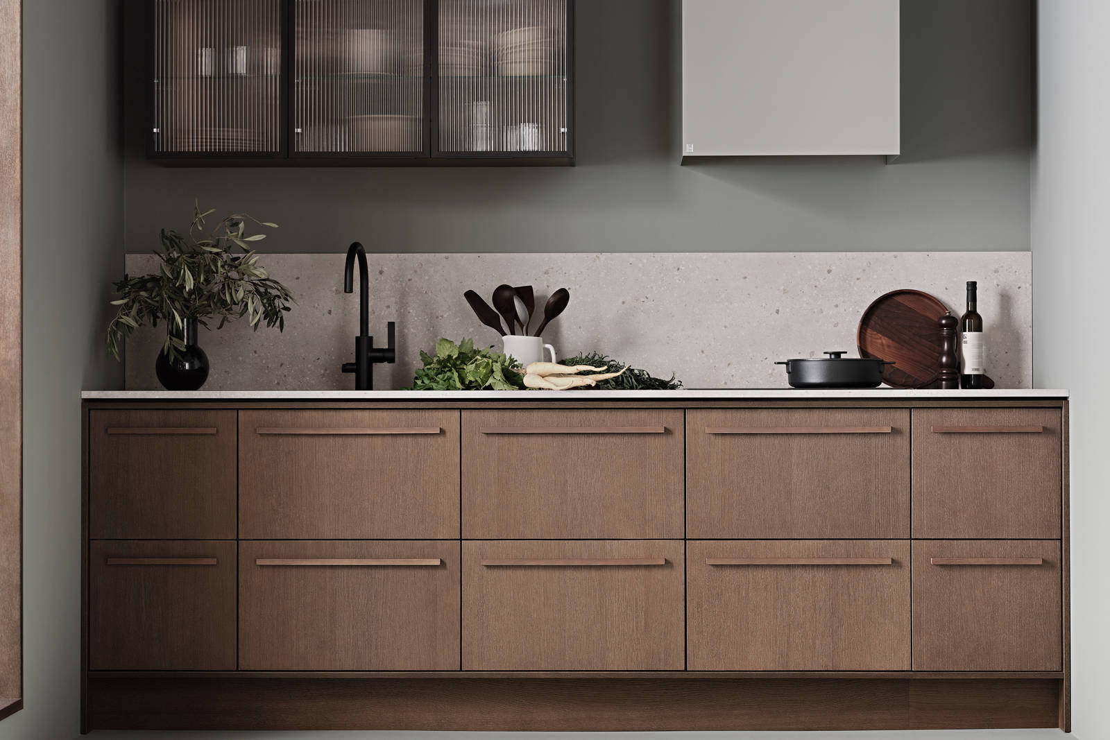 Køkken Forever Oak fra INVITA, mørk eg køkkenskabe med massiv tre mørk eg håndtag, komposit bordplade, sort armatur og vitrineskab med riflede glas i tynd, sort aluminiumsramme