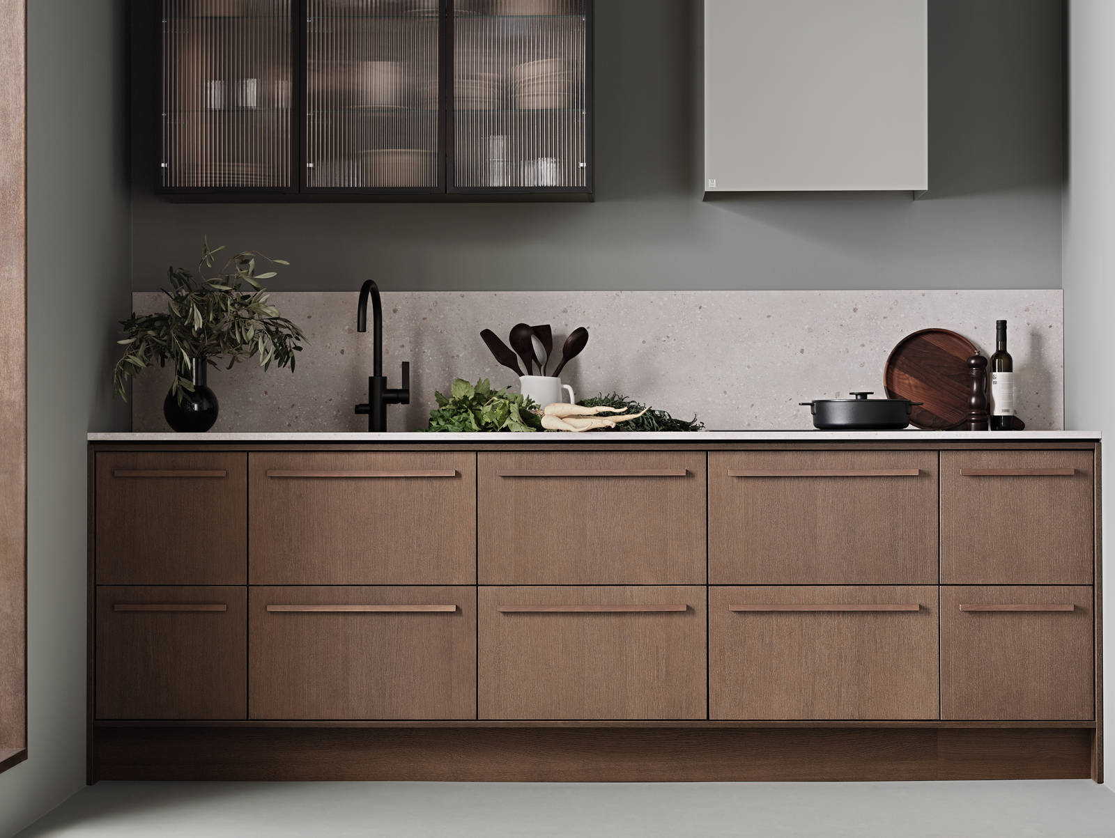 Brunbetsat ek-kök Signatur Ekbacken från Marbodal med matchande bänkskiva och stänkskydd, vitrinskåp med räfflat glas i svart aluram