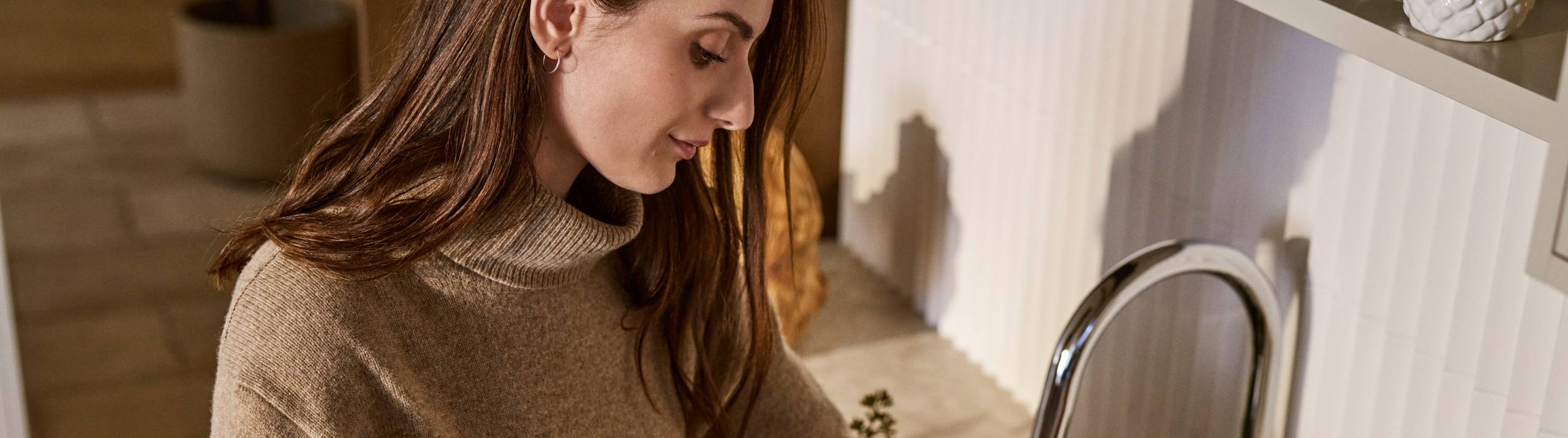 Kvinde setter blomster i vas