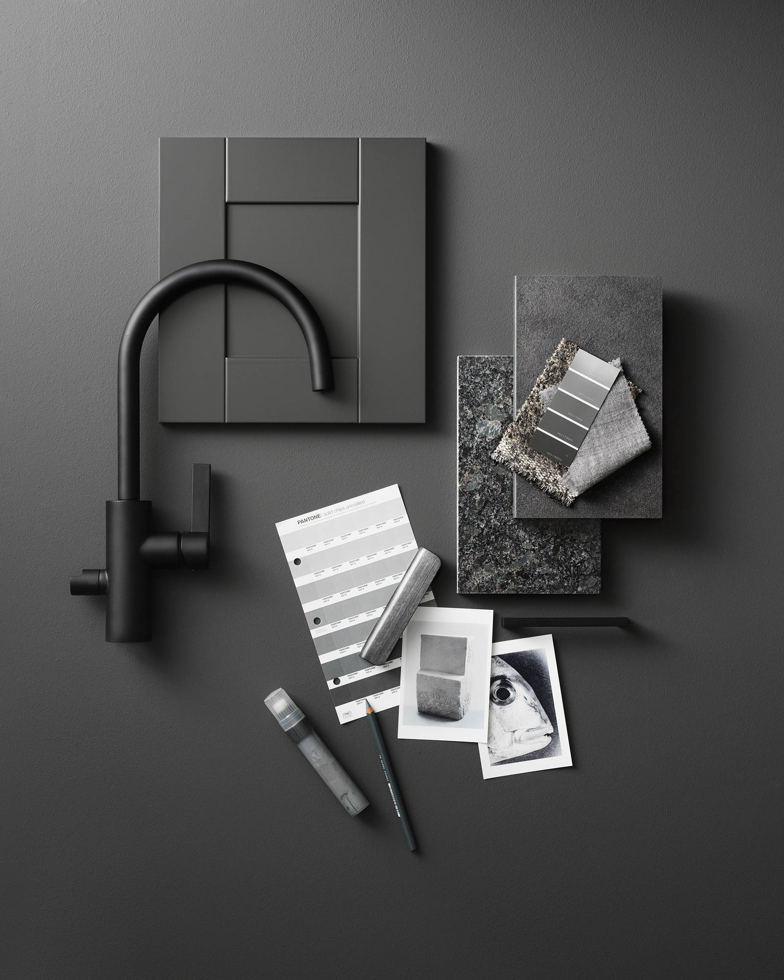 Mörkgrå kökslucka med ram, svart rundad blandare från tapwell, färgprover, två sorters grå marmor
