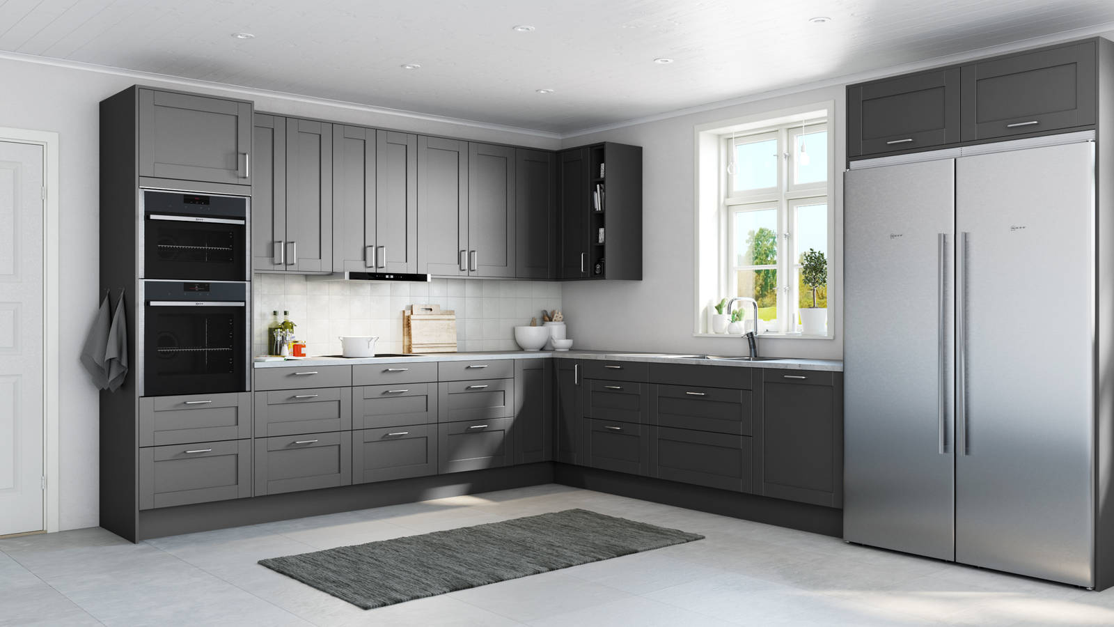 Det mysiga och romantiska köket Form, en ramlucka med slät spegel, i den mörkgrå kulören Granit, med integrerade ugnar och kyl/frys i rostfritt stål.