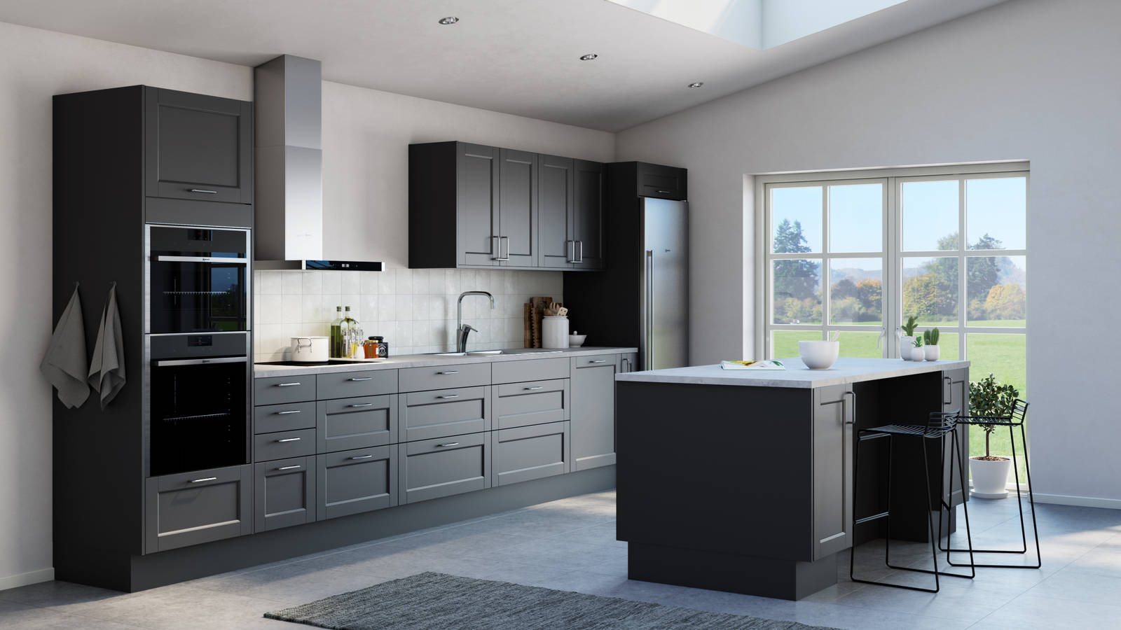 Det både klassiska och lantliga köket Fagerö med ramlucka i den mörkgrå kulören Granit, med integrerade ugnar och kyl/frys i rostfritt stål, och köksö.