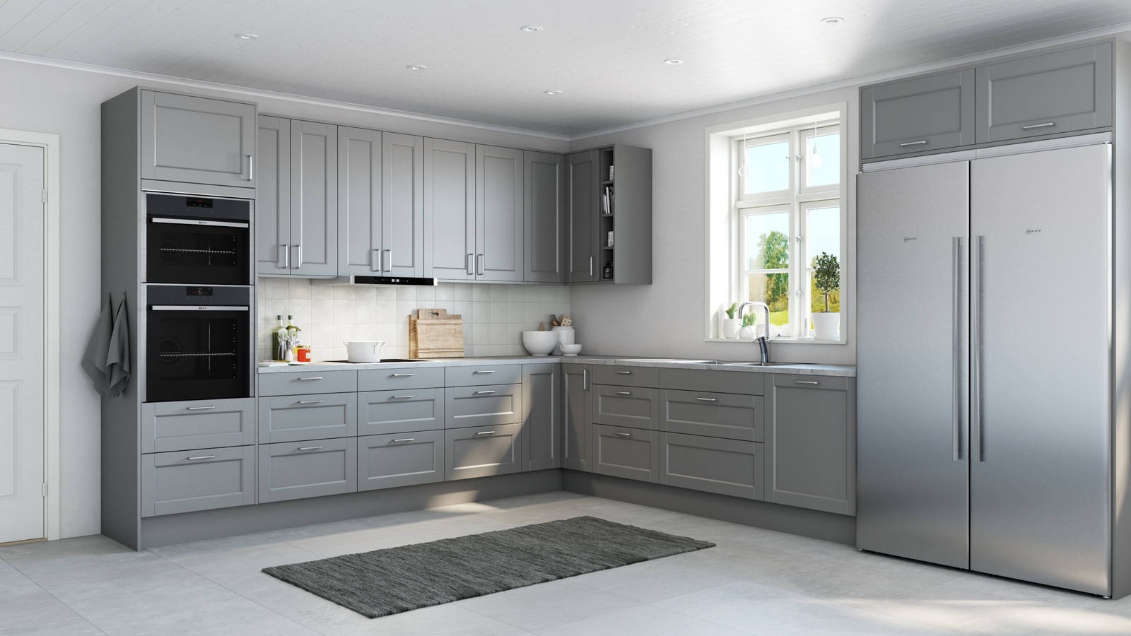 Det både klassiska och lantliga köket Fagerö med ramlucka i den grå kulören Åska, med Integrerade ugnar och Kyl/frys i rostfritt stål.