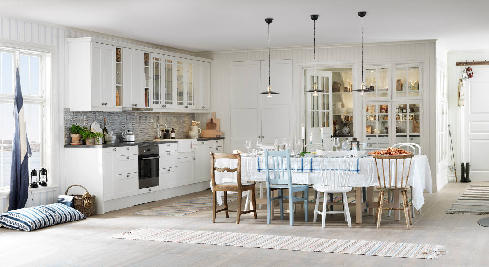 Köket Fagerö Frost. Tillsammans med vackra vitriner, matchande kakel och lugna färger ger detta kök en känsla av skärgård och med en flirt åt tidigt 1900-tal. Bänkskivan med stenkaraktär och en tidstypisk blandare i nedfälld porslinsho förstärker intrycket ytterligare.