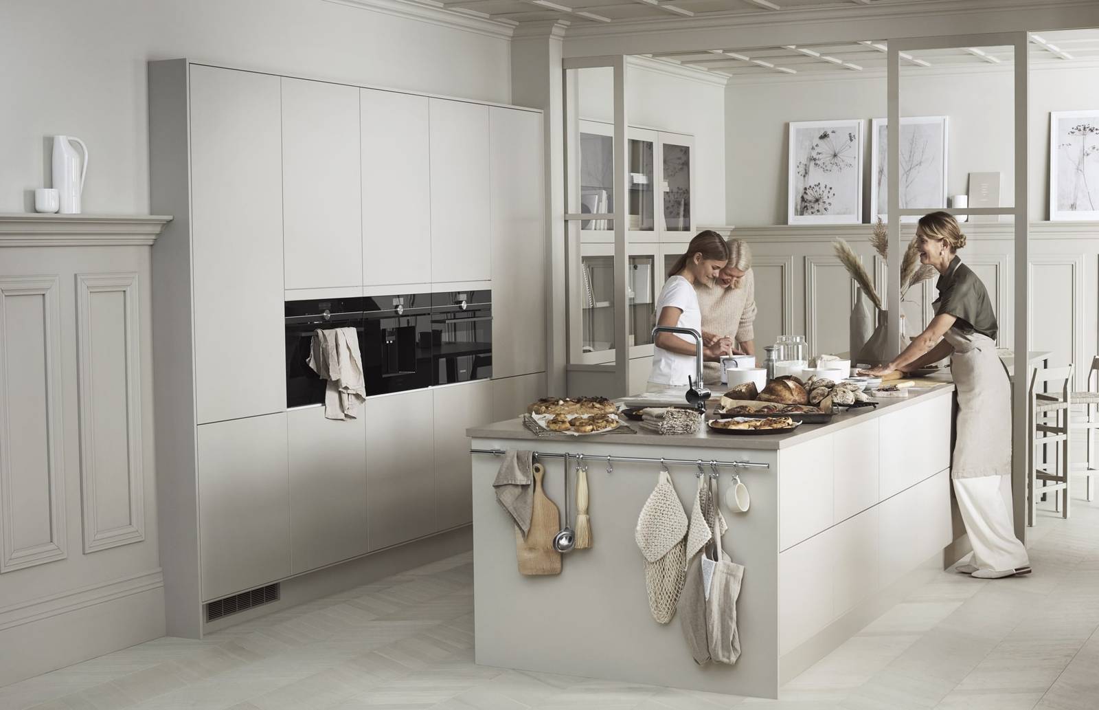 En familiebakst i det moderne beige Line kjøkkenet fra Sigdal med glatte dører i fargen Korn