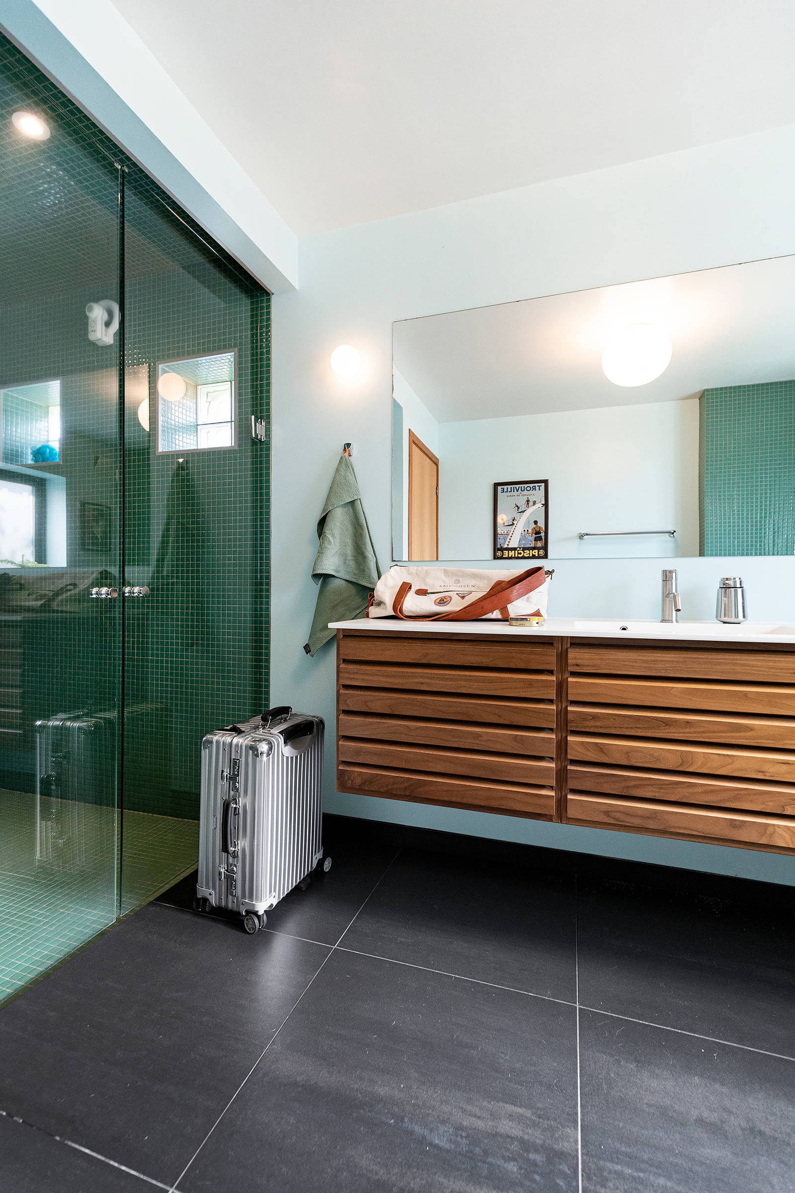 Badeværelset er indrettet med uno forms originale Classic design i valnød og smaragd-grønne mosaik-fliser, der matcher Trouville vintage posteren