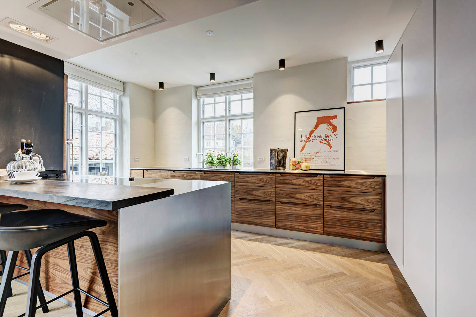 De varma valnötsfronterna kontrasteras av det svala stålet på bordsskivan