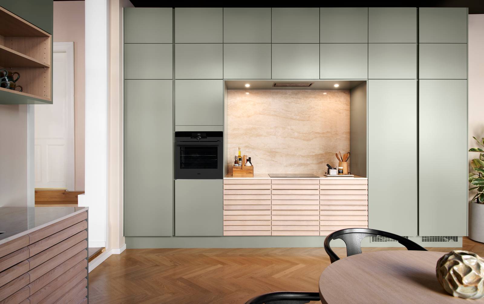 grebsfrie grønne køkkenet Highline Salvie med indfræsede greb i lågerne fra INVITA kombineret med med af egetræskøkken Ikon med håndsorterede lameller i massiv eg.