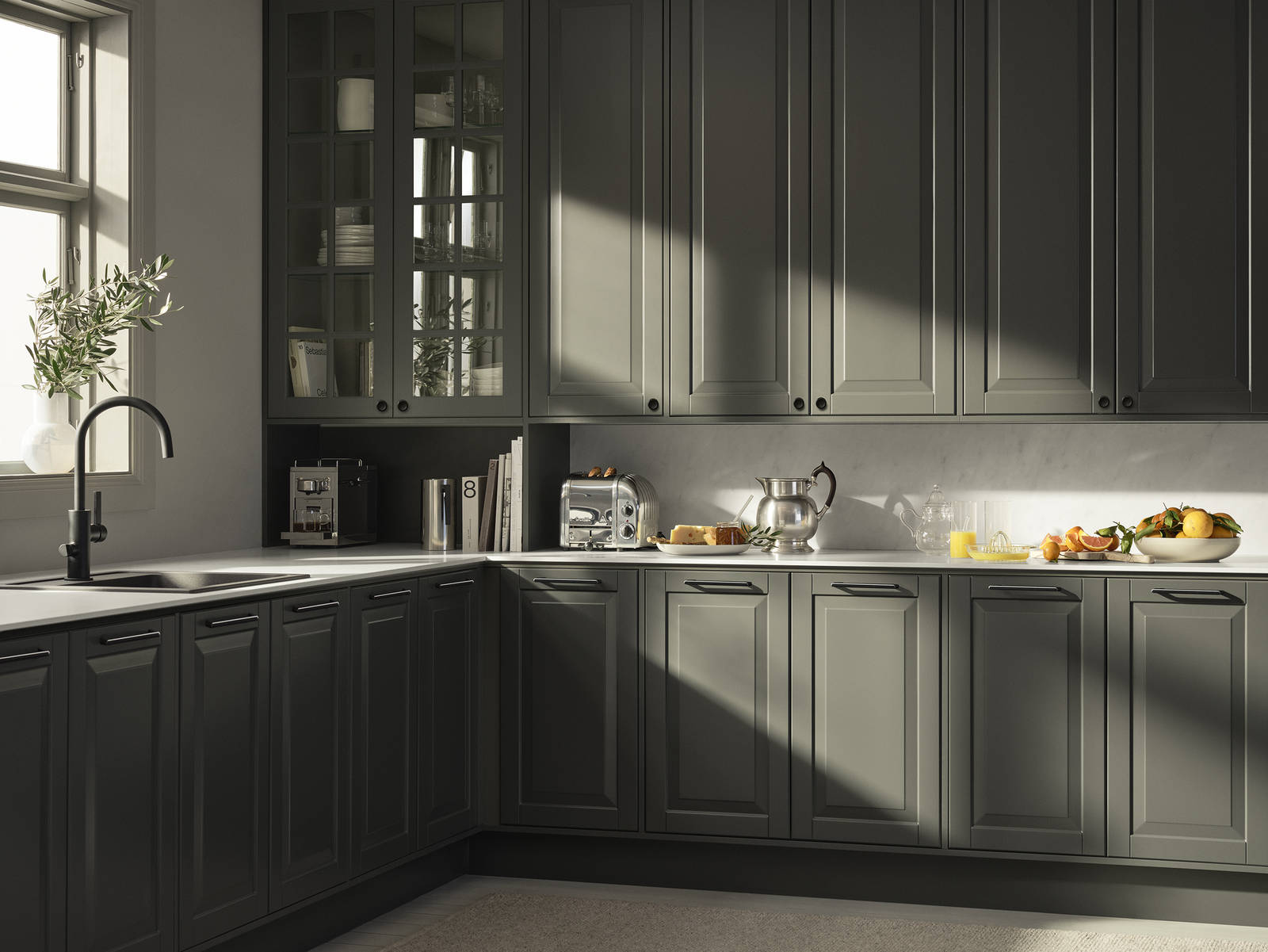 Mørkegrønt landkøkken Nordic Oliven fra INVITA med fyldningslåger, sort håndtag, vitrineskab med sprosselåger og hvid marmor laminatbordplade