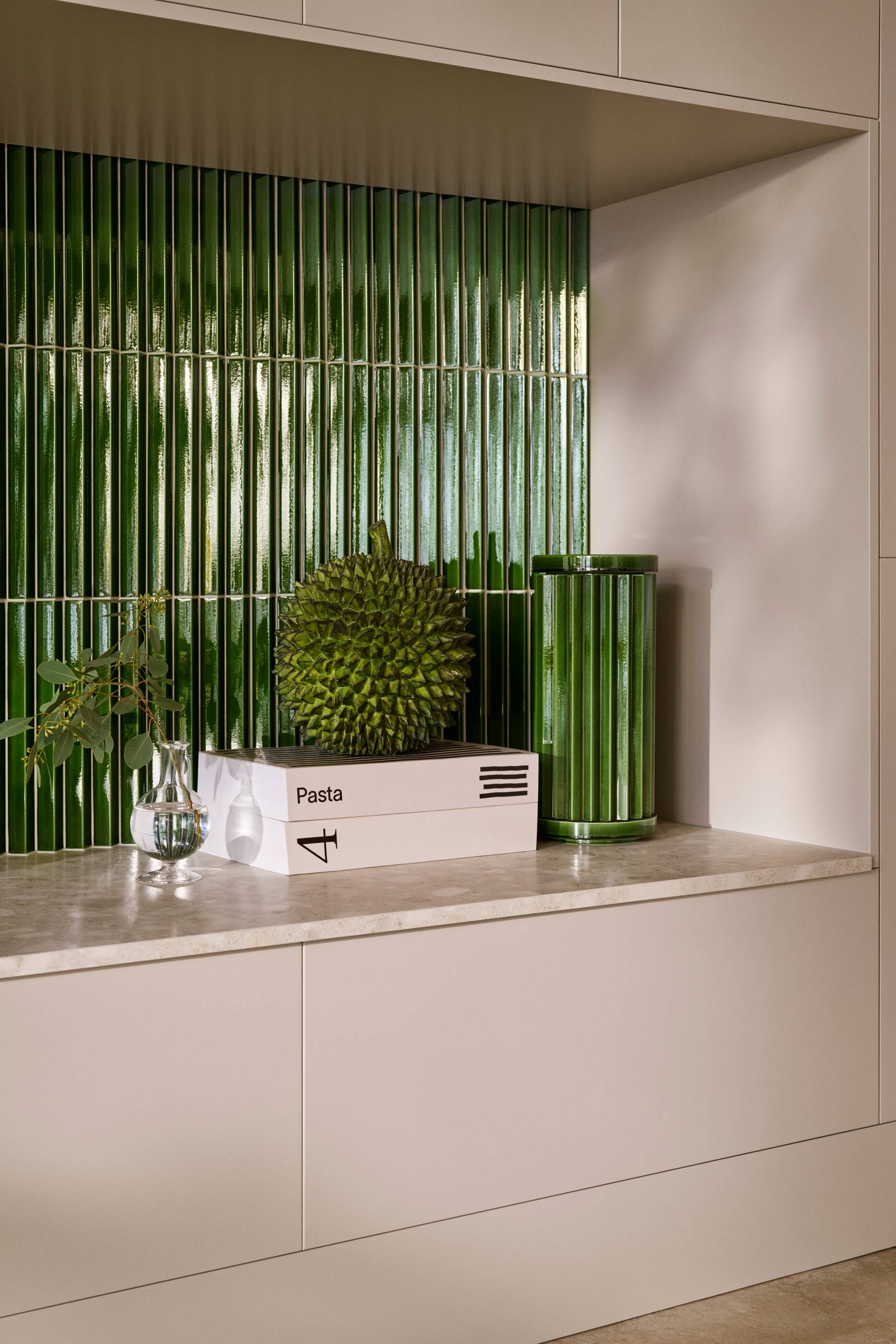 Nærbillede av benk Athena Sand med  grønne fliser bak