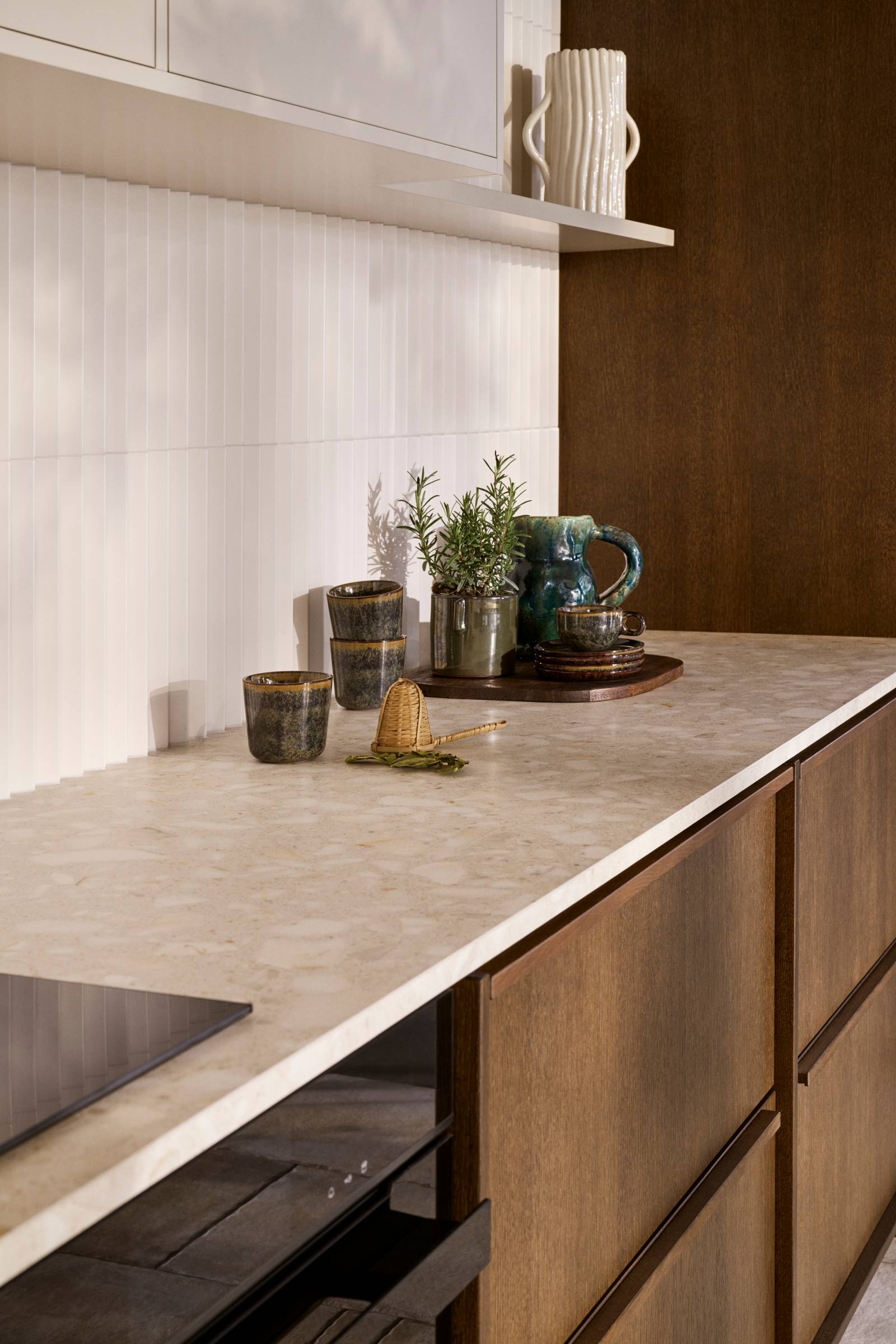 Nærbillede av lys bordplade i  mørk eg køkkenet Forever Oak fra INVITA med massiv tre håndtag