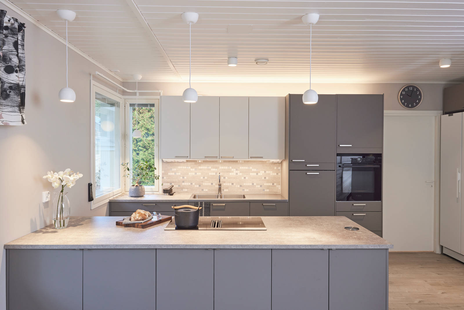 Trendikäs ja kestävä tummanharmaa ja valkoinen supermattalaminaatti keittiö keittiösaarekkeella, ruostumattomasta teräksestä valmistetut kahvat, supermatta laminaattitaso